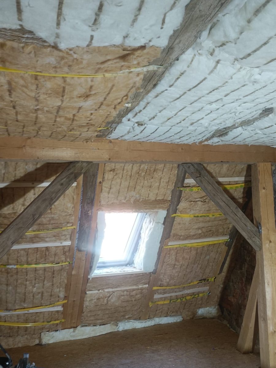 Dachgeschoss im Rohbau: gedämmte Dachschrägen, Kehlbalken und Dachfenster